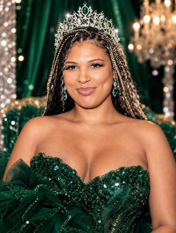 Woman wearing a sparkling emerald green dress and jeweled crown.