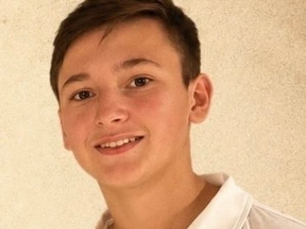 Smiling teenage boy wearing a white shirt.
