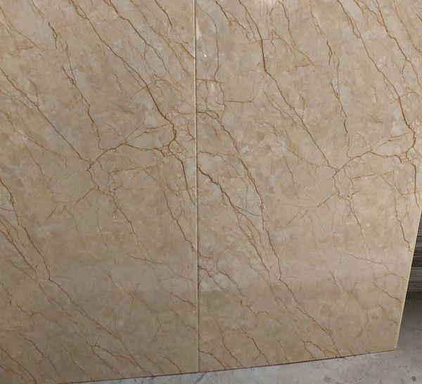 Two beige marble slabs with natural veining patterns.