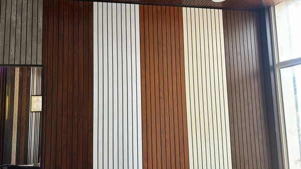 Striped vertical wooden paneling in varying shades beside a bright window.