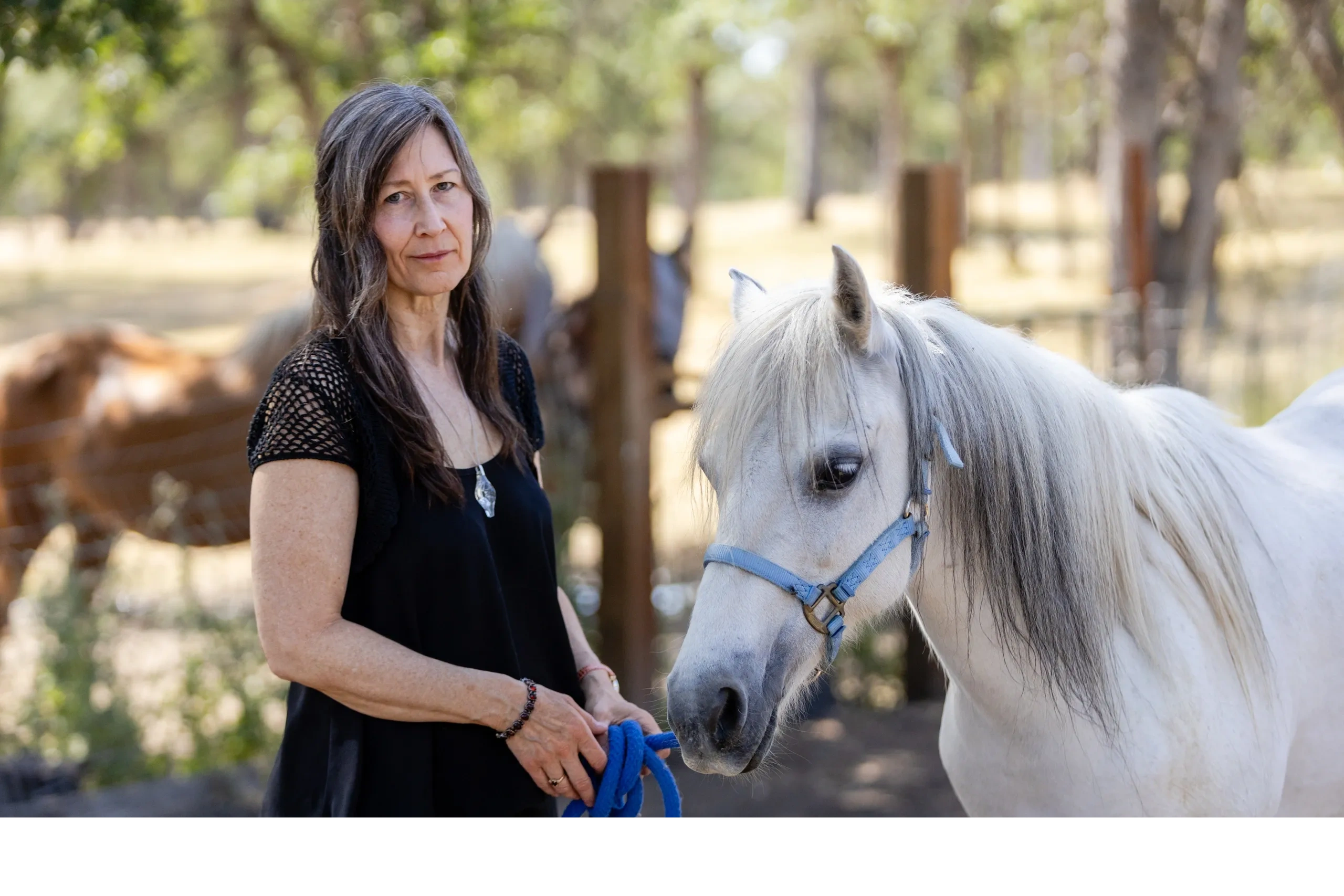 A woman standing beside a horse