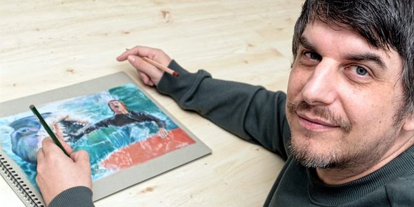 An image showing artist Neil McGregor completing artwork