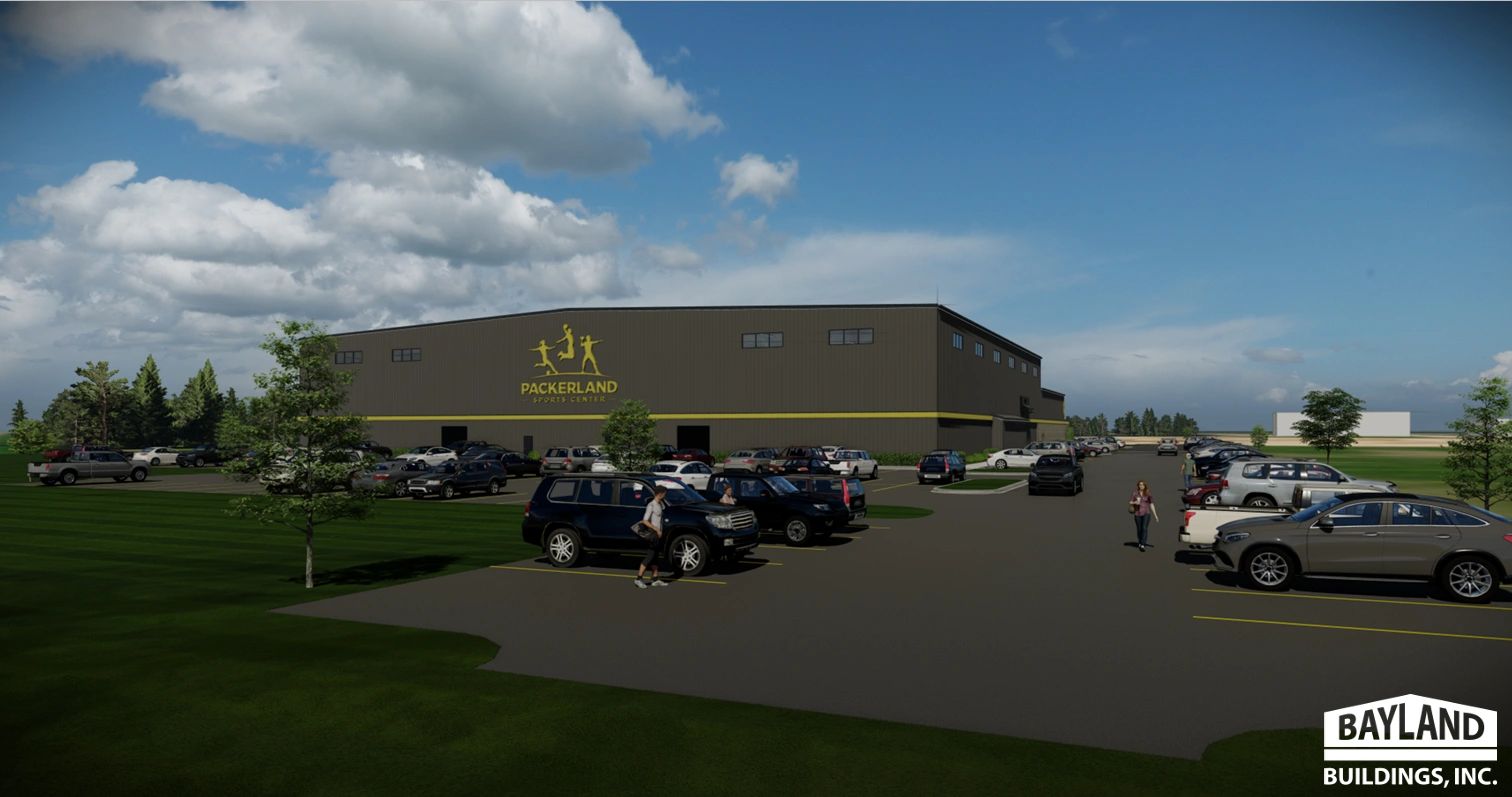 Modern Packerland Sports Center with a full parking lot under a partly cloudy sky.