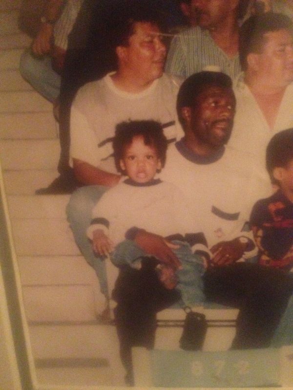 A man holding a young child on his lap, sitting on stairs with others nearby.