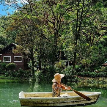 La imagen muestra a una mujer remando en Bote en el lago  de Sueños del Bosque durante el tour de 1 