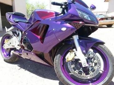 A sleek, sporty motorcycle with a shiny purple and maroon body