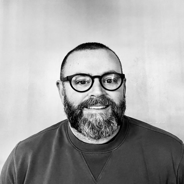 A man wearing glasses and smiling.
