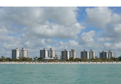 Beachfront condominiums under a cloudy sky.