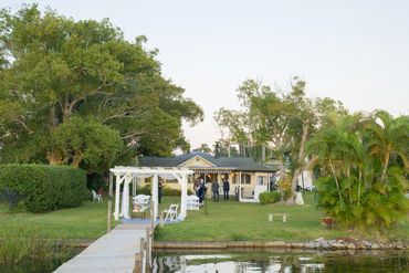 A waterfront home with a dock and lush green surroundings.