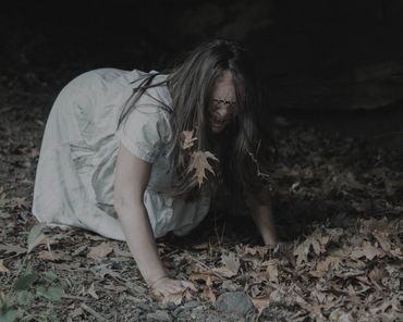 Frightened woman on hands and knees unable to see with eyes stapled closed.