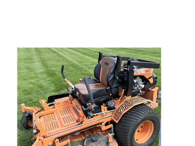 Orange zero-turn lawn mower parked on freshly cut grass.