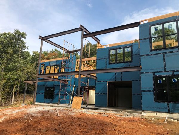 A modern house under construction with steel framing beams.
