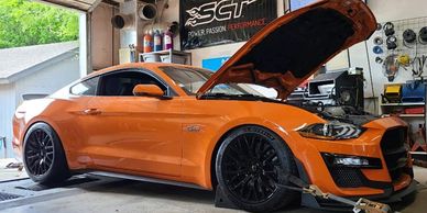 Orange mustang GT with hood open. 
