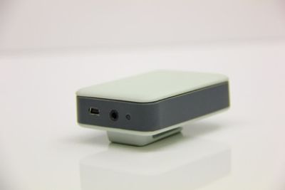Compact electronic device with ports on a white surface.