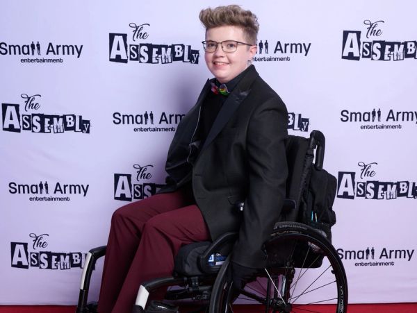 Mac smiles in wheelchair on the red carpet at the CBC The Assembly season 1 premiere event
