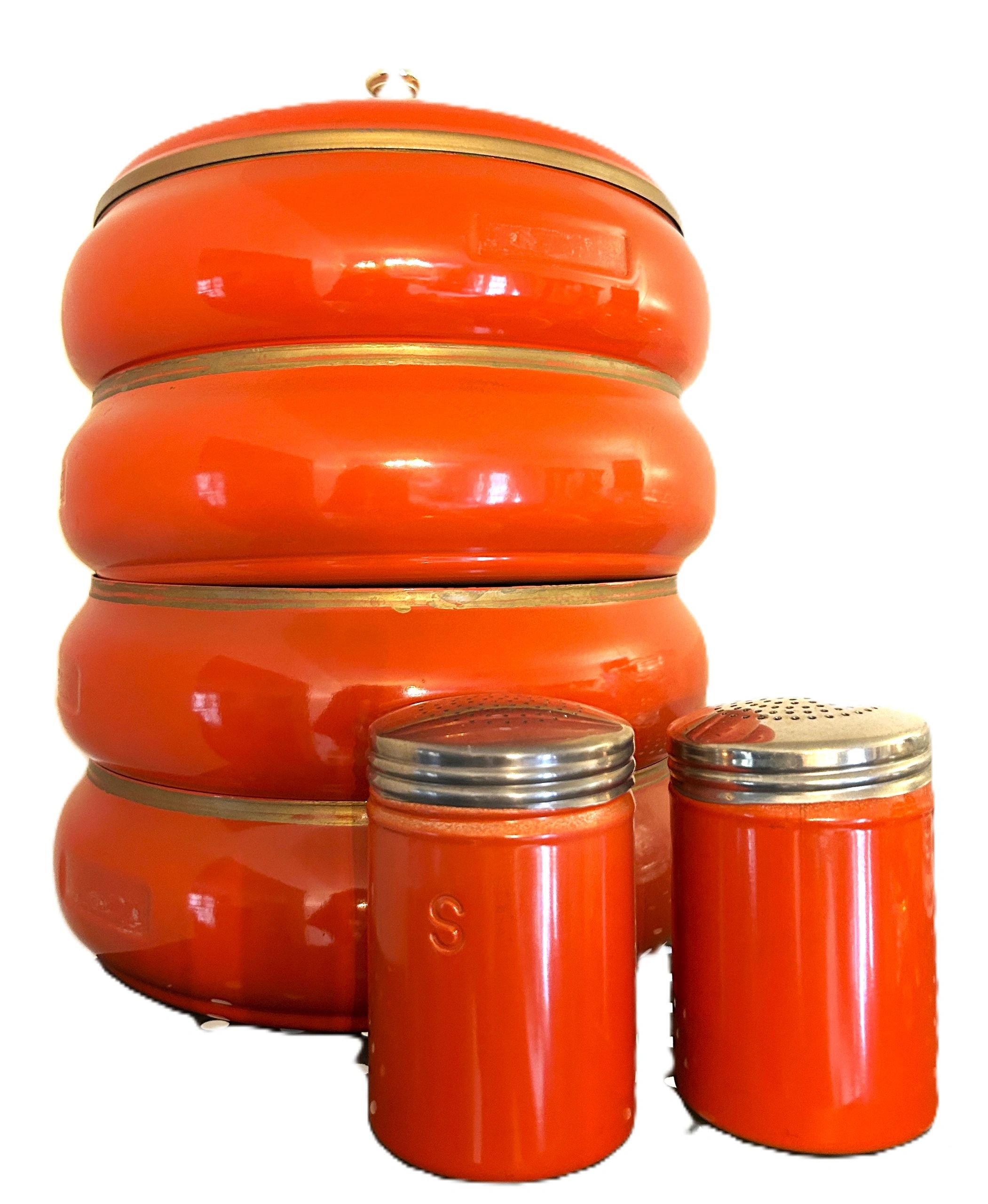 Retro orange kitchen canisters with salt and pepper shakers.