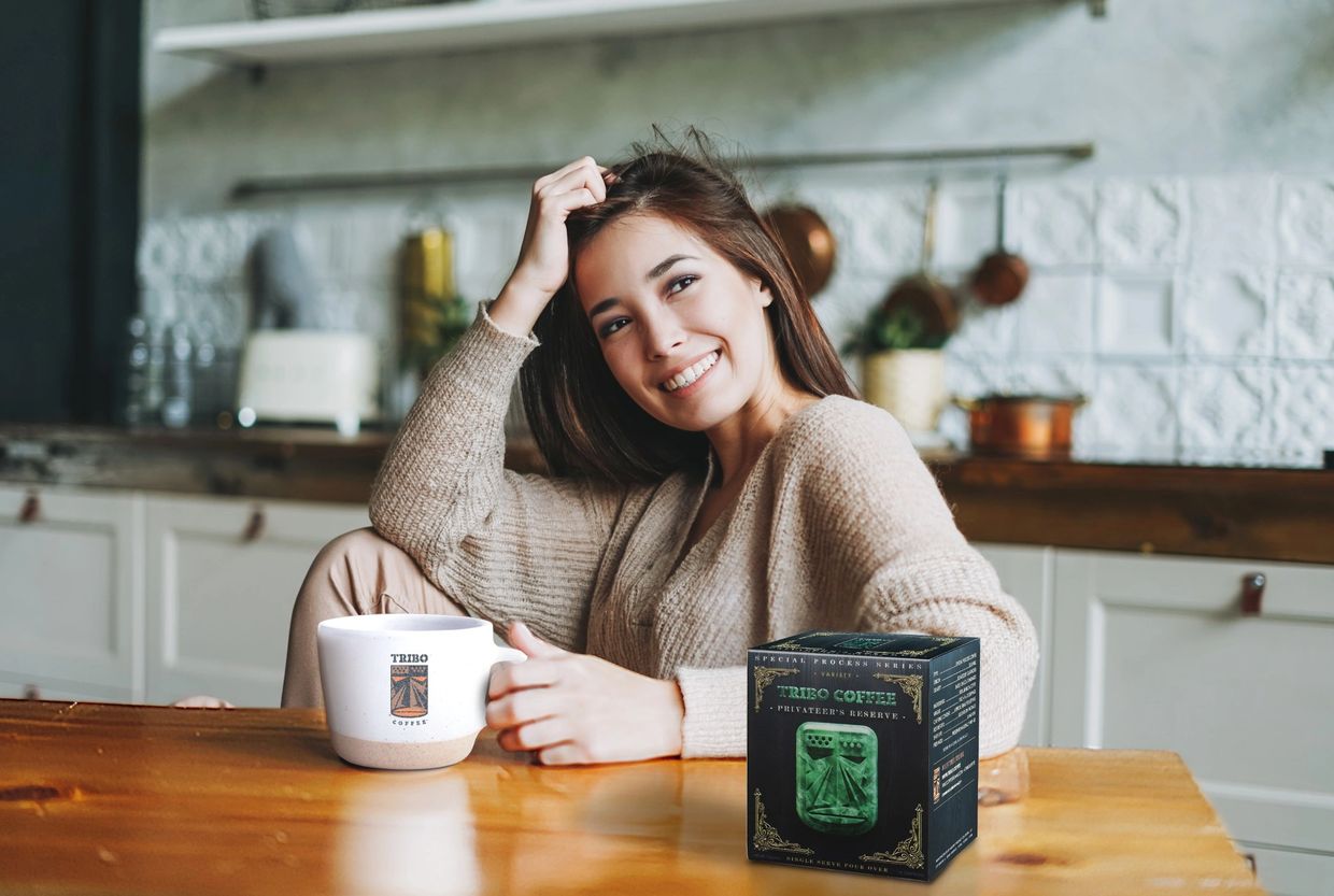 Beautiful woman enjoying TRIBO Coffee Privateer's Reserve at home in her kitchen.