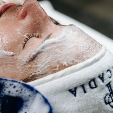 Person with face mask applied, relaxing with eyes closed.