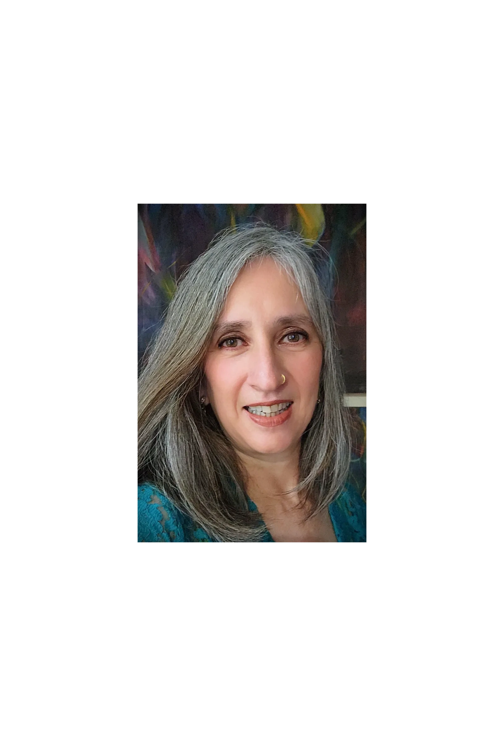 Close-up of a smiling woman with gray hair and a nose ring.