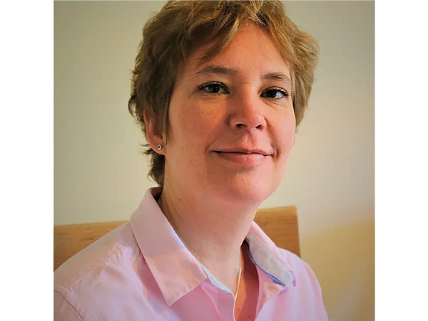 a smiling woman wearing a pink shirt