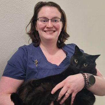 female veterinarian holding her black cat 