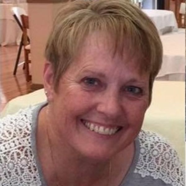 Smiling woman with short blonde hair.