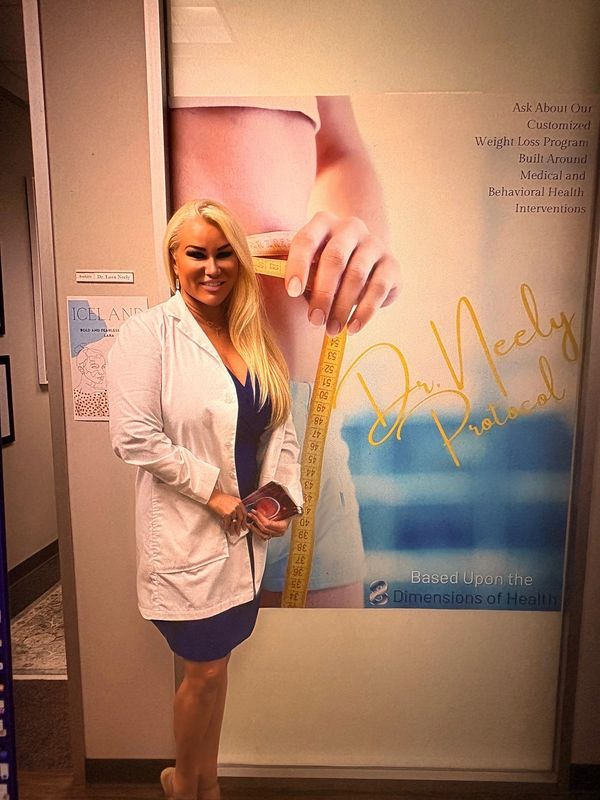 A woman in a white coat stands next to a weight loss program poster.