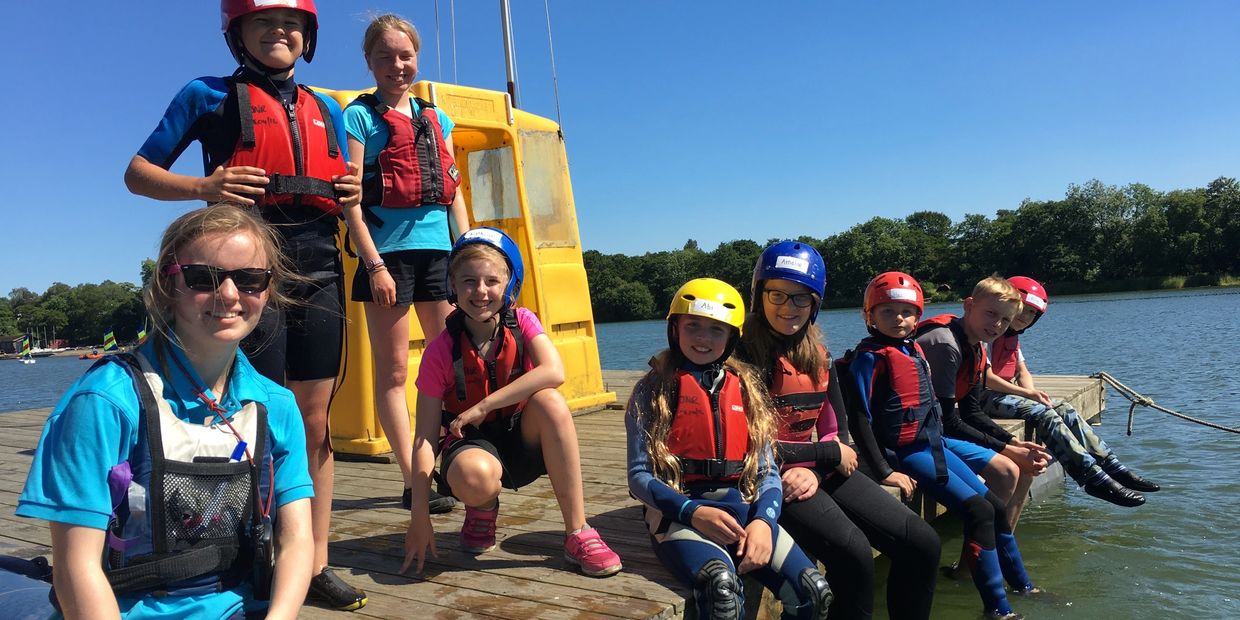 Dinghy instructors and their students relaxing on the pontoon during Summer school.