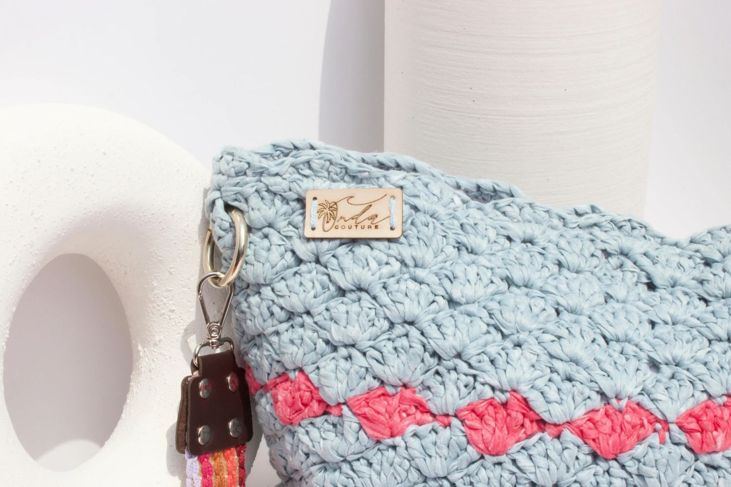 Light blue crocheted handbag with coral accents and Inda Couture label.