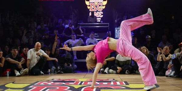 Dancer performing breakdance move on stage.