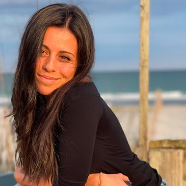 Smiling young woman outdoors near the beach.