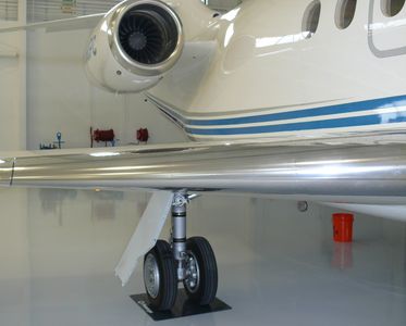Falcon 2000 business jet parked on Wheel Coaster in Hangar.