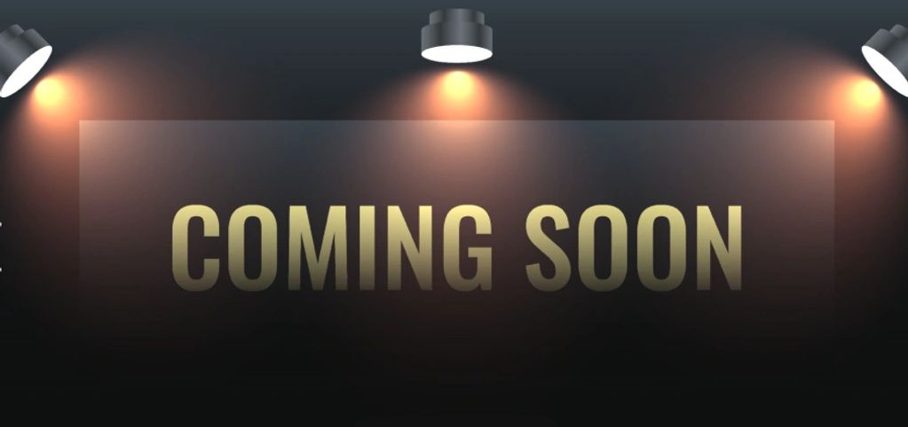 Golden 'Coming Soon' text illuminated by spotlights.
