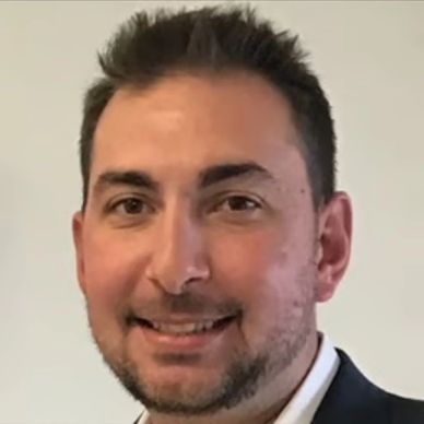 Portrait of a smiling man with short hair and a beard.
