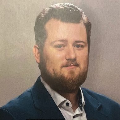 Man with beard and suit jacket.