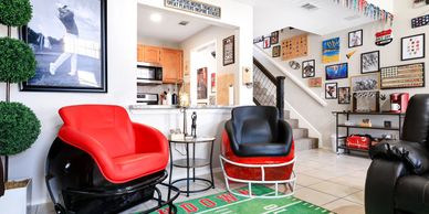 Living room decorated with sports themed decor including football helmet chairs