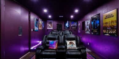 Theater room painted in purple and surrounded by movie posters