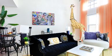 Living room decorated in Andy Warhol style with a giraffe statue