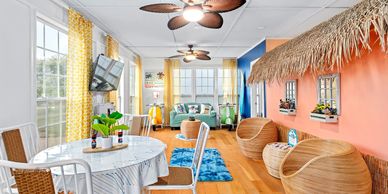 Bright living room with beach vibes, palm fan and vespa end tables