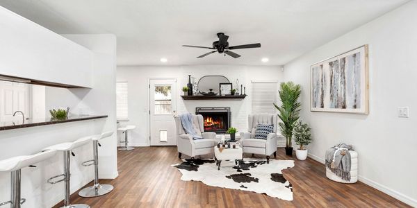 Living room with fireplace, white arm chairs and cow hide rug