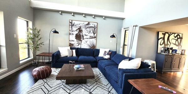 Sophisticated urban cowboy themed short term rental with blue sectional and live edge tables
