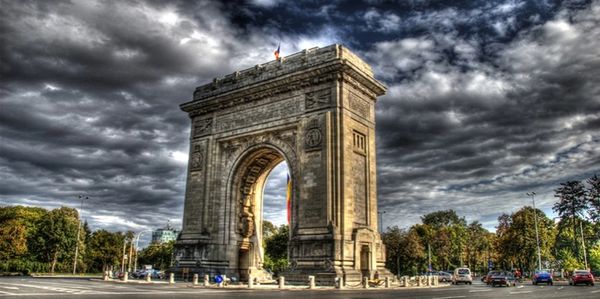 Arch monument under a dramatic cloudy sky.