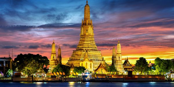 Illuminated temple at sunset with vibrant sky.