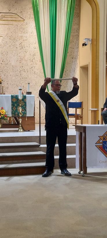 priest holding a rope while speaking