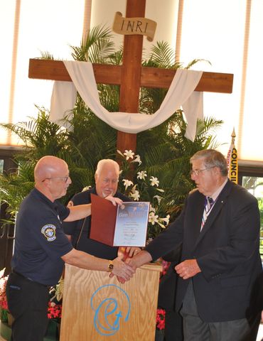 men shaking hands in front of a cross