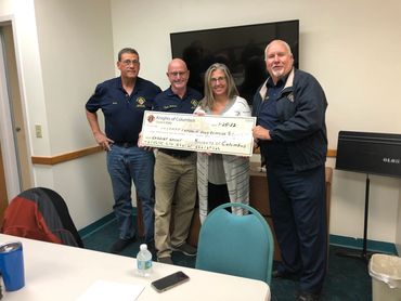 group of men presenting a large check