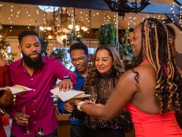 Friends exchanging envelopes and enjoying a festive celebration.