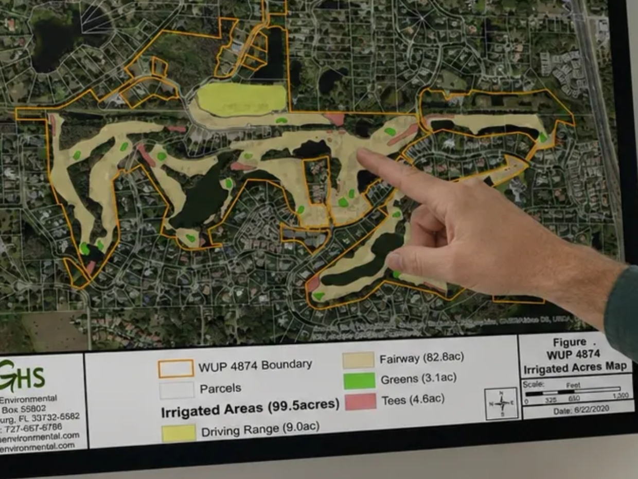 Hand pointing to a golf course irrigation map.