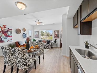 Bright open living and dining area with patterned chairs and modern decor.