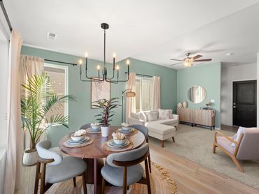 Modern dining and living room with pastel walls and cozy furniture.